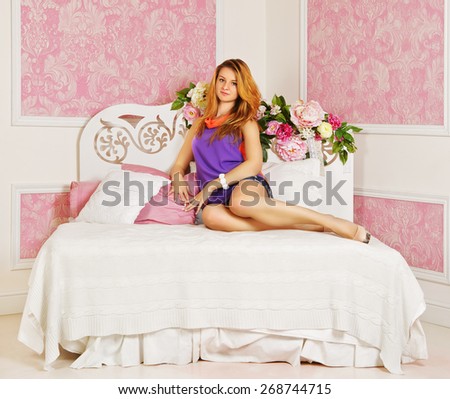 young sexy girl in pink bedroom lying on bed