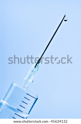 syringe with drop on needle, blue background