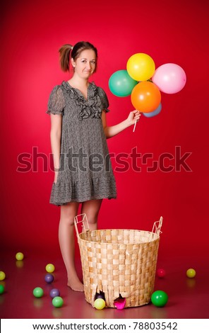 funny girl with toys and balloons, red background