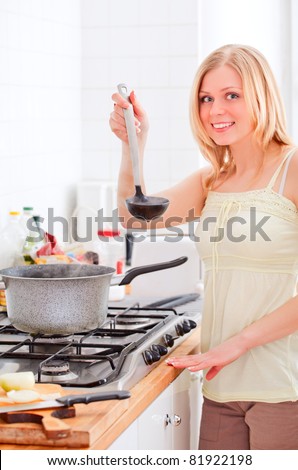 cute young woman cooking in bright kitchen