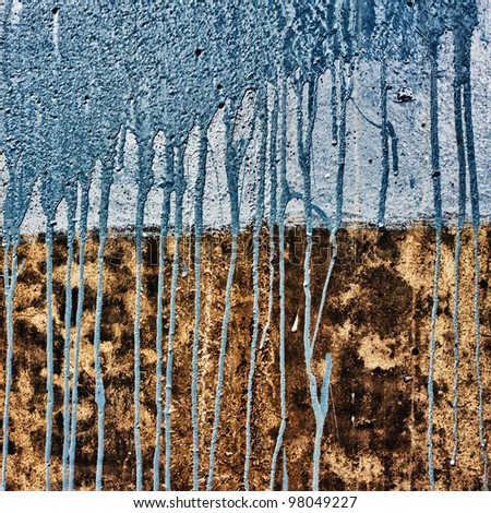 concrete wall with drips of blue paint