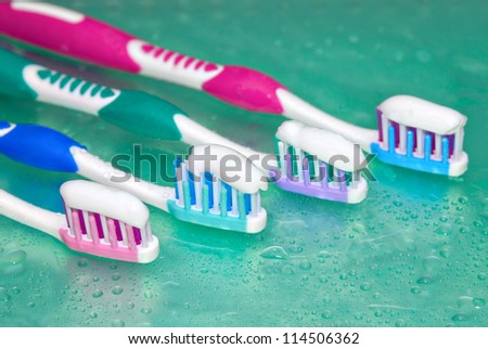 Toothbrushes in water drops on blue glass