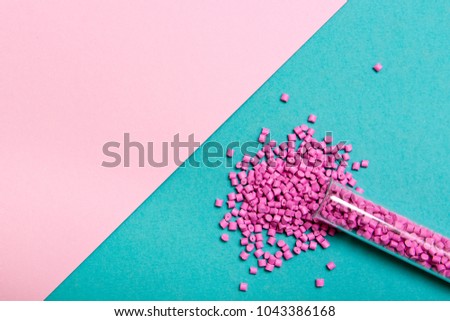 Plastic pallets . Plastic raw materials in granules for industry. Polymeric dye pink on a turquoise background. Plastic granules after processing of waste polyethylene and polypropylene.Polymer
