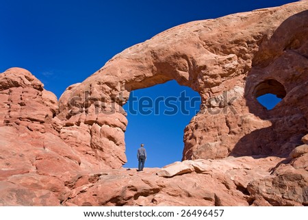 Hiker admiring natural wonders of Arches National park, Utah