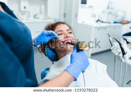 Beautiful young woman having dental treatment at dentist\'s office.