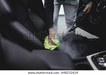 Cleaning interior of the car with hot steam. Selective focus.