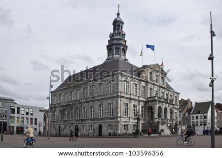 MAASTRICHT,  APRIL 26: Unidentified people walk on a Market Square in front of a town hall in Maastricht, Netherlands on April 26, 2012. Town hall was built in the 17th century by Pieter Post.