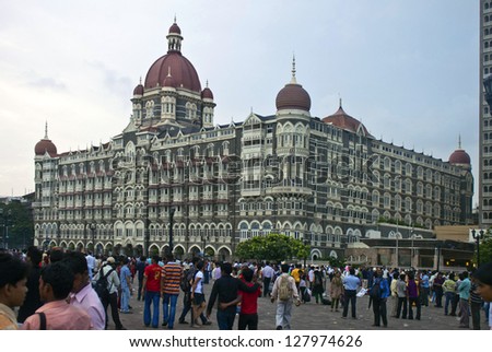 MUMBAI, INDIA - AUGUST 21: A group of people walk in front of Taj Mahal Palace & Tower hotel in Mumbai on August 21, 2011. On 26 November 2008, the hotel was attacked by terrorists.