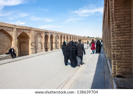 ISFAHAN, IRAN - MARCH 8: People walk along Si-o-se bridge on March 8, 2013 in Isfahan, Iran. Bridge built in 1602  is 298 m long and 14 m wide.