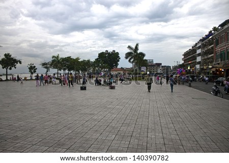 PNOM PENH, CAMBODIA - JULY 17: People walk at riverbank in Pnom Penh, Cambodia on July 17, 2012. Pnom Penh is the capital and largest city of Cambodia.. Metropolitan area is home to about 2.2 million.