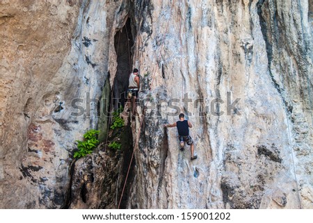 RAILAY. THAILAND - SEPTEMBER 4: Rock climbing on Railay beach on September 4, 2013 in Railay, Thailand. Railay beach is one of the most popular rock climbing locations in Asia.