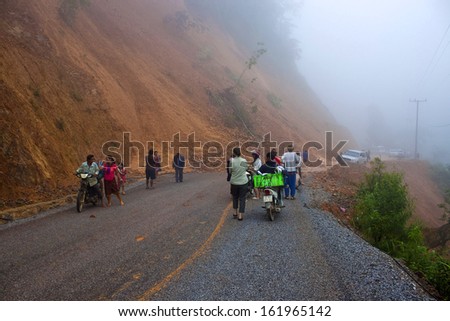 NORTHERN LAOS - AUGUST 14: People wait for clearing a road after landslide on August 14, 2012 in Northern Laos. Landslides are common in Laos because annual rainfall is up tu 4 m per year,
