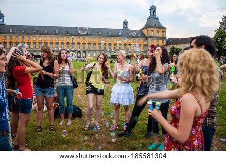 BONN, GERMANY - JULY 22: Students of University in Bonn blow bubbles in front of main building of University on July 22, 2013 in Bonn, Germany. University Bonn have 31,000 students.