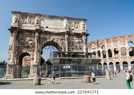 ROME, ITALY - JUNE 24, 2015: Tourists visit the famous Arch of Constantine, a triumphal monument in Rome, situated between the Colosseum and the Palatine Hill.
