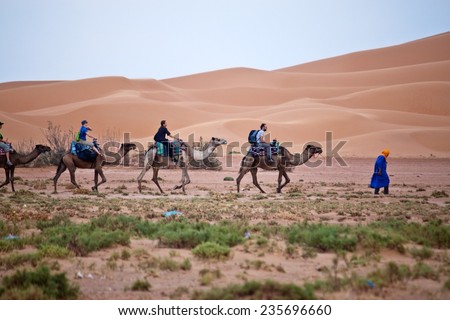 ERG CHEBBI, MOROCCO - AUGUST 3: Camel caravan with tourists in the desert on August 3, 2010 in Erg Chebbi, Morocco. Erg Chebbi is part of Sahara desert.