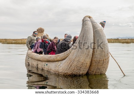 TITICACA, PERU - MAY 15, 2015: Visitors on a reed boat near Uros floating islands, Titicaca lake, Peru