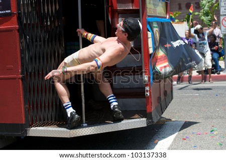 LONG BEACH - MAY 20: Man dancing on a truck, holding a pole, at the Long Beach Lesbian and Gay Pride Parade 2012 on May 20, 2012 in Long Beach, California.