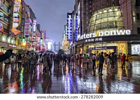 SHANGHAI, CHINA - MAY 2, 2015: Visitors and neon lights at Nanjing Road. It is the main shopping street of Shanghai, China, and is one of the world\'s busiest shopping streets.