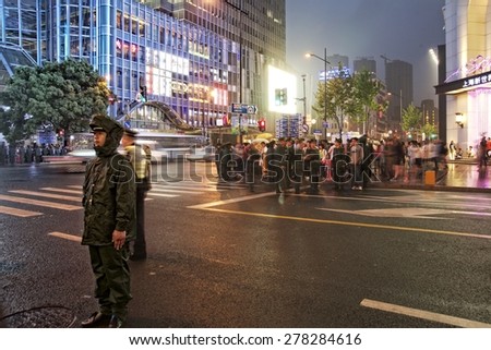 SHANGHAI, CHINA - MAY 2, 2015: Policeman on duty making sure the traffic flows at Nanjing Road. It is the main shopping street of Shanghai, China, and is one of the world's busiest shopping streets.