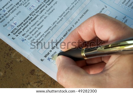 Hand of a man answering the United States Census 2010. He\'s marking \