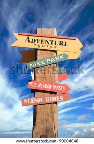 Wooden pole with signs pointing in different directions