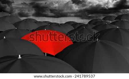 Individuality and thinking different concept of a red umbrella in a crowd of black ones