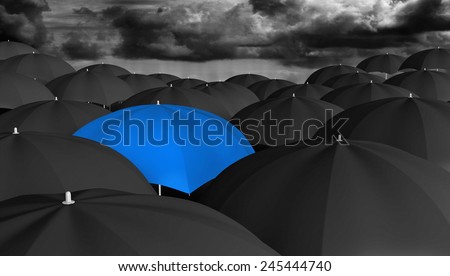 Leadership and innovation concept of a blue umbrella in a crowd of black ones