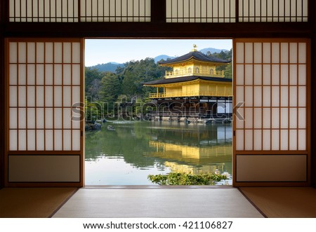View of a beautiful Japanese golden temple and pond garden seen through open rice paper doors