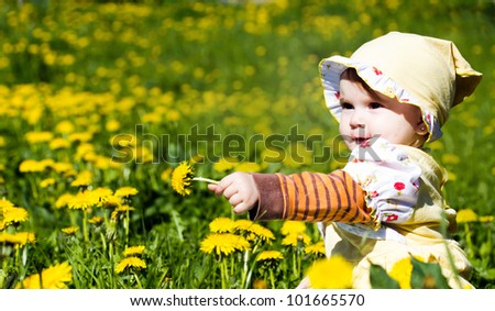 Cute little baby on the dandelion meadow