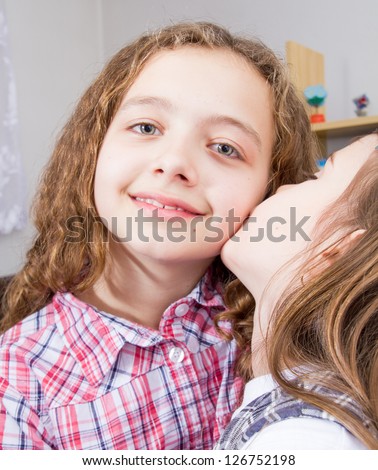 Younger sister kissing her older sister
