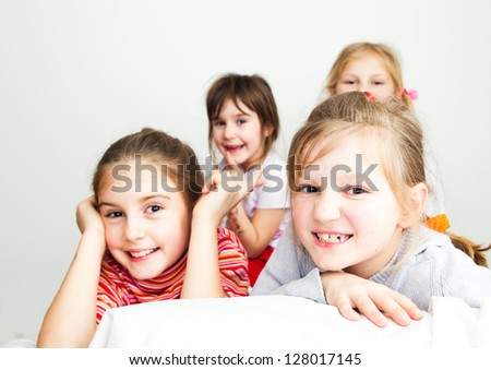 A group of four little girls have a fun and posing together - looking at camera