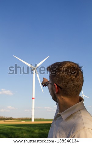 Young man standing in front of windmill