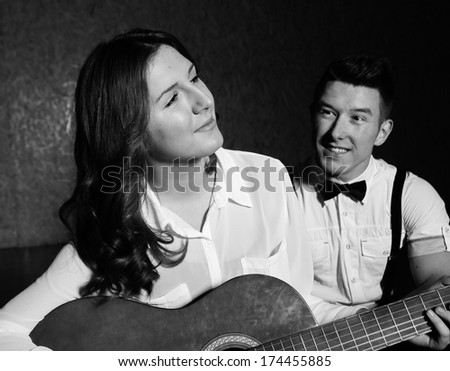 Young beautiful couple  playing guitar