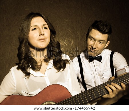 Young beautiful couple  playing guitar