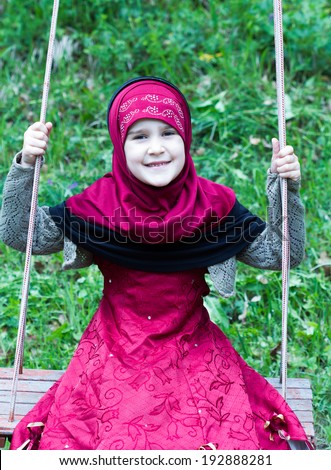 Little muslim girl in a grass
