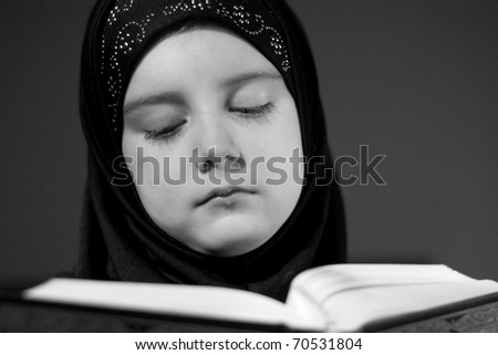 Beautiful Muslim girl reading holy book Koran