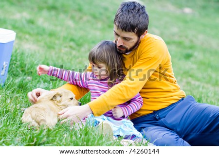 father and daughter on picnic - playing with dog