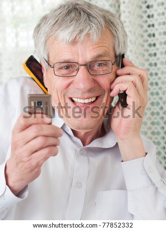 Very busy older man using a few phones in same time