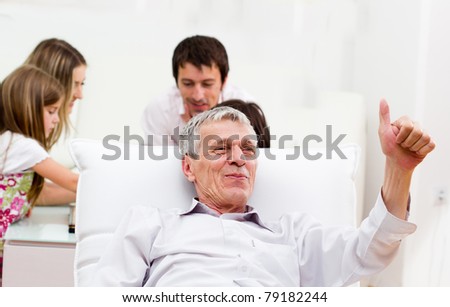 Happy elderly man portrait - sitting on sofa indoor