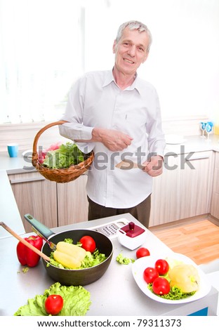 Elderly man preparing vegetable launch in the kitchen