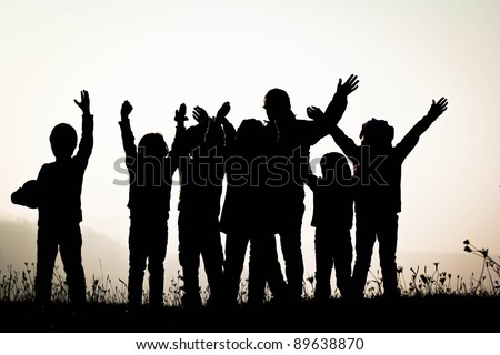 Group of happy children on sunset - silhouetted