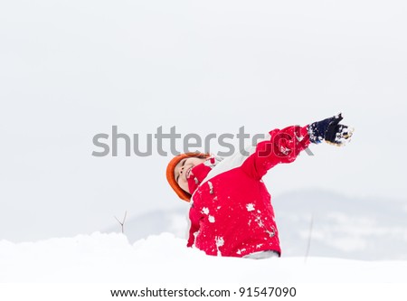 Happy Little boy having fun in the snow