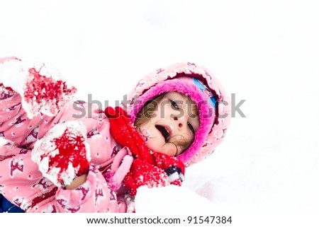 Happy little kid is playing in snow
