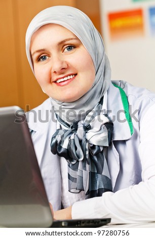 Beautiful young muslim woman using laptop in office