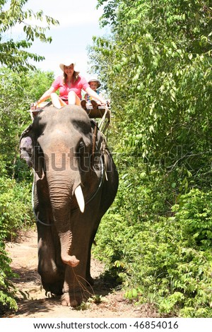 Elephant trekking. Mother and son on elephand back.