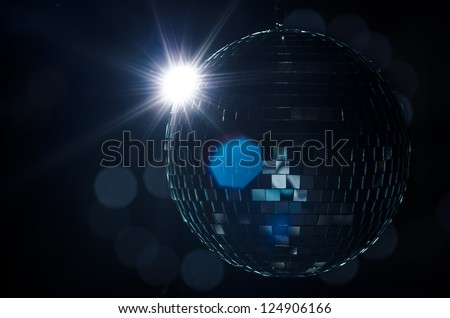 A disco ball with light flare and blurry lights on background. A nightlife image to be used as example on party fliers.