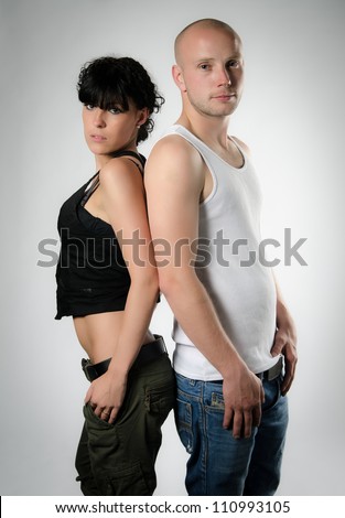 Portrait of a sexy woman and a good looking man standing back to back