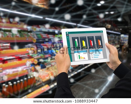 iot smart retail in the futuristic concept, the retailer hold the tablet and use augmented reality technology monitor data of out of shelve, price, planogram, campaign of compliance in the real time