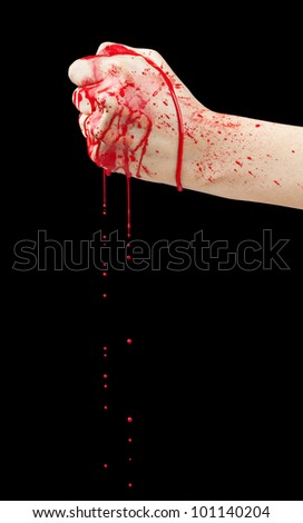 A bloody hand making a fist with blood dripping down isolated on black.
