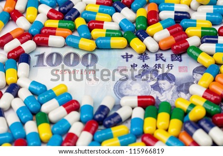 A one thousand NT dollar bill covered with colorful pills with focus on the number 1000.